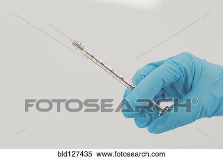 Lab technician holding syringe close-up of hand View Large Photo Image Stock Photography - Lab technician holding syringe close-up of hand. Fotosearch