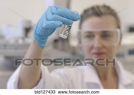 Lab technician looking at sample bottle in laboratory focus on hand View Large Photo Image Stock Image - Lab technician looking at sample bottle in laboratory focus on hand. Fotosearch