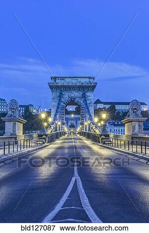 Lion statues and illuminated streetlamps along Chain Bridge, Budapest, Hungary View Large Photo Image Stock Photo - Lion statues and illuminated streetlamps along Chain Bridge, Budapest, Hungary. Fotosearch