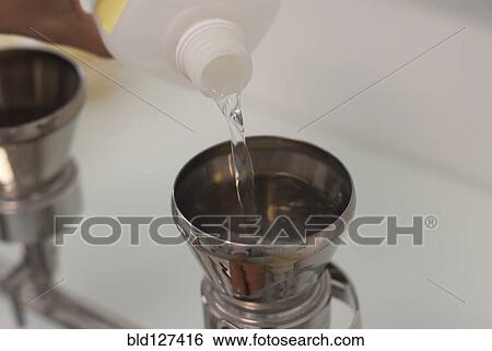 liquid being poured into measuring instrument View Large Photo Image Stock Photograph - liquid being poured into measuring instrument. Fotosearch