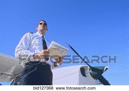 Low Angle Shot of a Pilot Holding a Map and Standing by a Private Propeller Plane View Large Photo Image Stock Photo - Low Angle Shot of a Pilot Holding a Map and Standing by a Private Propeller Plane. Fotosearch