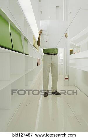 Male architect looking at plan in recently finished office building View Large Photo Image Stock Photo - Male architect looking at plan in recently finished office building. Fotosearch