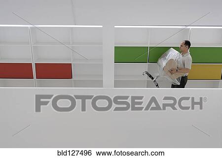 Male office worker carrying new chair wrapped in plastic sheet View Large Photo Image Stock Photograph - Male office worker carrying new chair wrapped in plastic sheet. Fotosearch