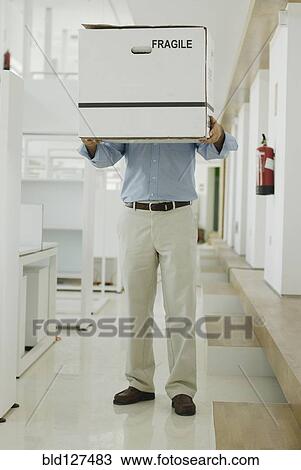 Man carrying box in office View Large Photo Image Stock Image - Man carrying box in office. Fotosearch