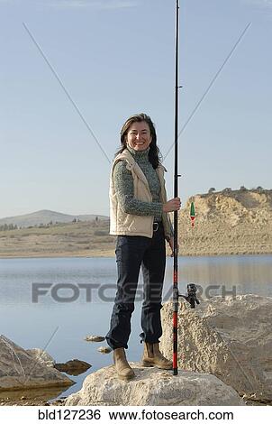 Mature woman at lakeside holding fishing rod smiling portrait View Large Photo Image Stock Photograph - Mature woman at lakeside holding fishing rod smiling portrait. Fotosearch
