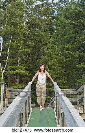 Stock Photography - mature woman on wooden walkway. Fotosearch