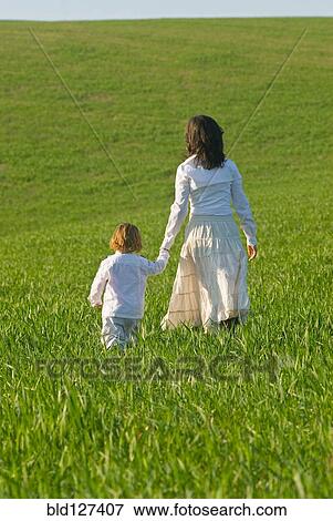 Mother and son holding hands in field rear view View Large Photo Image Stock Photo - Mother and son holding hands in field rear view. Fotosearch