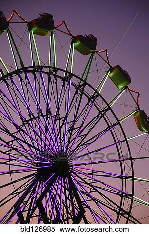 Stock Photography - Neon Ferris Wheel ride at amusement park at night. Fotosearch
