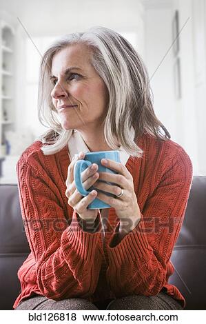 Stock Photo - Pensive Caucasian woman drinking coffee. Fotosearch