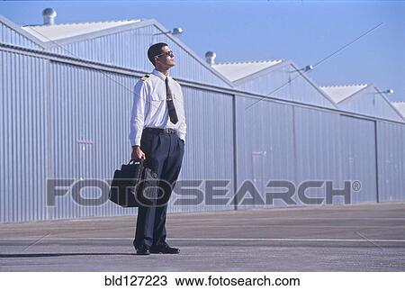 Pilot on tarmac looking at sky View Large Photo Image Stock Image - Pilot on tarmac looking at sky. Fotosearch