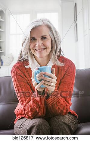 Portrait of Caucasian woman drinking coffee on sofa View Large Photo Image Stock Photo - Portrait of Caucasian woman drinking coffee on sofa. Fotosearch