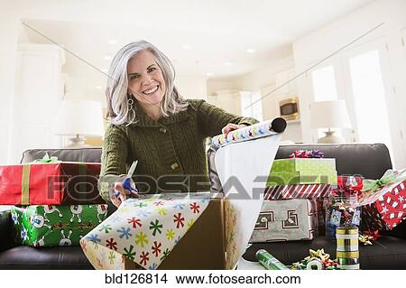 Portrait of Caucasian woman wrapping Christmas gifts View Large Photo Image Picture - Portrait of Caucasian woman wrapping Christmas gifts. Fotosearch