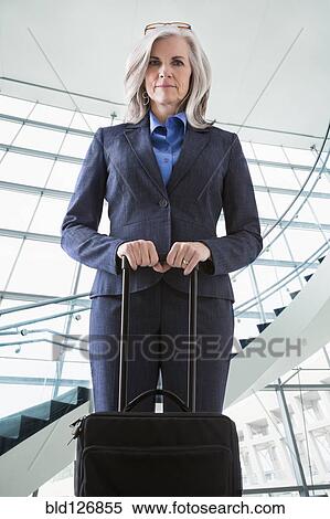 Portrait of confident Caucasian businesswoman with suitcase View Large Photo Image Stock Photography - Portrait of confident Caucasian businesswoman with suitcase. Fotosearch