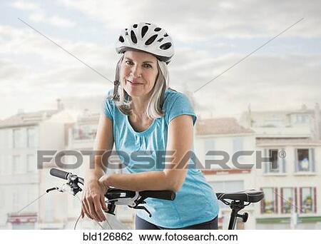 Portrait of confident Caucasian woman on bicycle View Large Photo Image Stock Image - Portrait of confident Caucasian woman on bicycle. Fotosearch