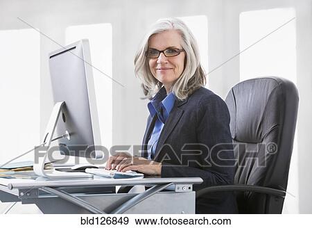 Portrait of confident Caucasian working at computer View Large Photo Image Stock Photo - Portrait of confident Caucasian working at computer. Fotosearch