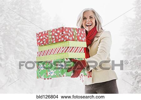 Picture - Portrait of enthusiastic Caucasian woman with Christmas gifts. Fotosearch