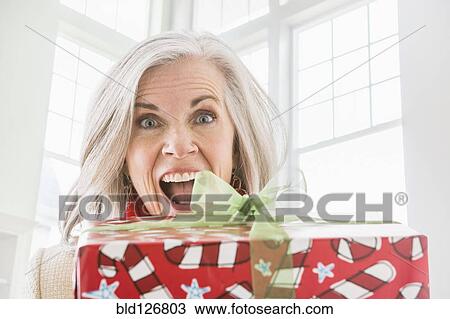 Portrait of enthusiastic Caucasian woman with Christmas gift View Large Photo Image Stock Image - Portrait of enthusiastic Caucasian woman with Christmas gift. Fotosearch
