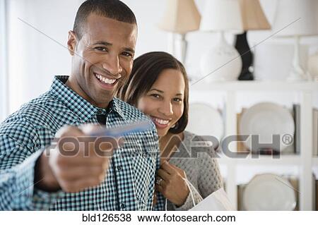 Portrait of happy couple paying with credit card in store View Large Photo Image Stock Photo - Portrait of happy couple paying with credit card in store. Fotosearch