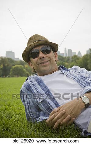 Portrait of Hispanic man laying in grass at park View Large Photo Image Stock Image - Portrait of Hispanic man laying in grass at park. Fotosearch
