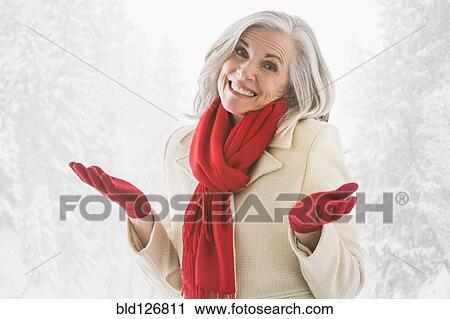 Stock Image - Portrait of shrugging Caucasian woman in warm clothing. Fotosearch