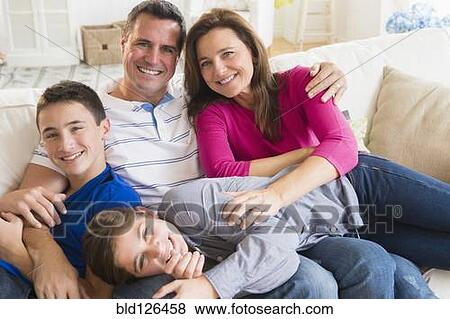 Stock Photo - Portrait of smiling Caucasian family on sofa. Fotosearch