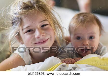 Portrait of smiling Caucasian girl with baby brother View Large Photo Image Stock Image - Portrait of smiling Caucasian girl with baby brother. Fotosearch