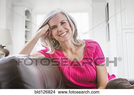 Portrait of smiling Caucasian woman on sofa View Large Photo Image Picture - Portrait of smiling Caucasian woman on sofa. Fotosearch