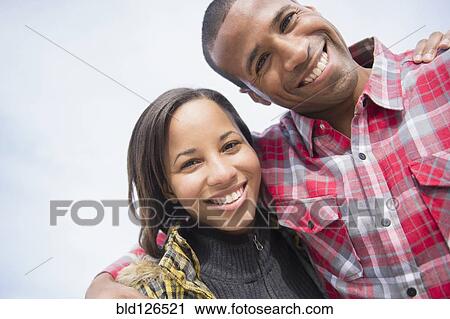 Stock Image - Portrait of smiling couple hugging. Fotosearch