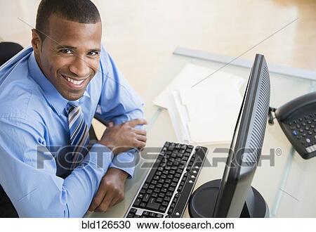 Portrait of smiling Hispanic businessman at computer View Large Photo Image Stock Image - Portrait of smiling Hispanic businessman at computer. Fotosearch