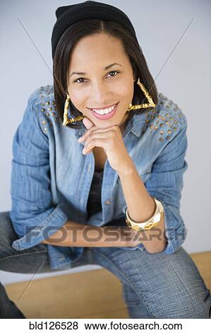 Stock Photo - Portrait of smiling mixed race woman with hand on chin. Fotosearch