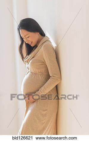 Pregnant Japanese woman holding stomach View Large Photo Image Stock Image - Pregnant Japanese woman holding stomach. Fotosearch