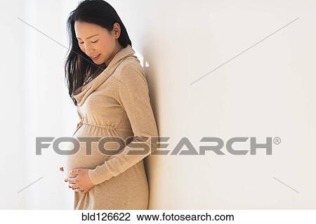 Pregnant Japanese woman holding stomach View Large Photo Image Stock Image - Pregnant Japanese woman holding stomach. Fotosearch