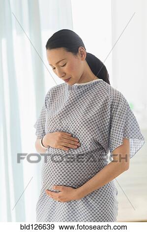 Pregnant Japanese woman in hospital gown View Large Photo Image Stock Photo - Pregnant Japanese woman in hospital gown. Fotosearch