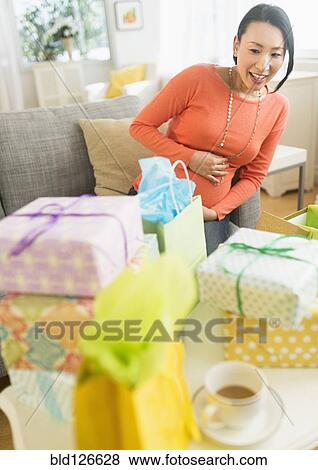 Pregnant Japanese woman looking at baby shower gifts View Large Photo Image Stock Photo - Pregnant Japanese woman looking at baby shower gifts. Fotosearch