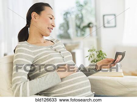 Pregnant Japanese woman looking at ultrasound image View Large Photo Image Stock Image - Pregnant Japanese woman looking at ultrasound image. Fotosearch