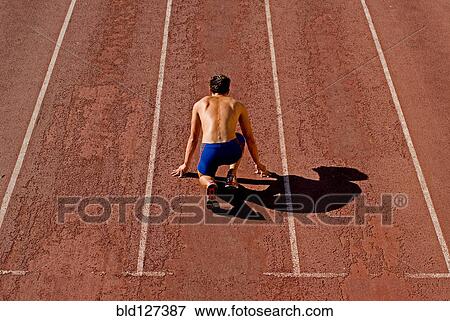 Runner on starting position of running track rear view View Large Photo Image Stock Photo - Runner on starting position of running track rear view. Fotosearch