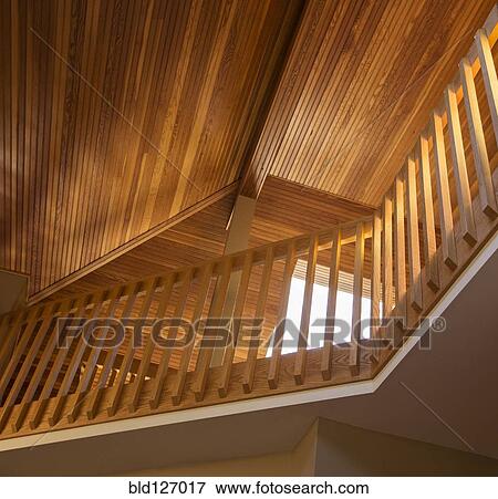 Slanted wooden ceiling above railing in house View Large Photo Image Stock Photo - Slanted wooden ceiling above railing in house. Fotosearch