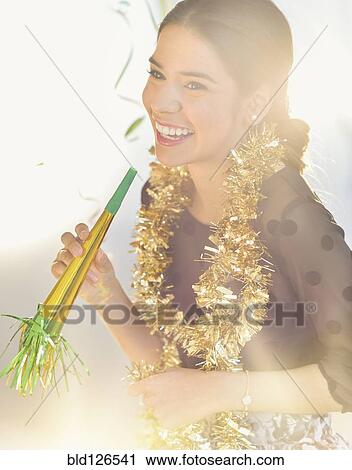 Stock Image - Smiling Hispanic woman celebrating New year's Eve. Fotosearch