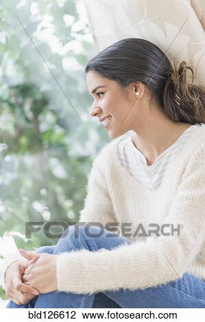 Smiling Hispanic woman looking out window View Large Photo Image Stock Image - Smiling Hispanic woman looking out window. Fotosearch
