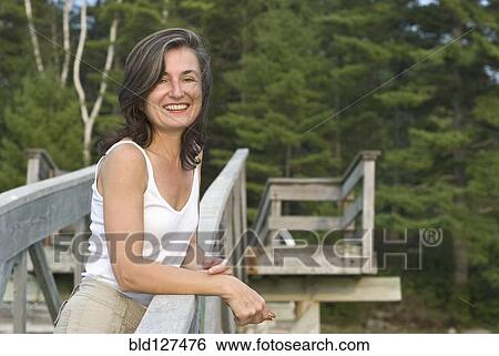 smiling woman on wooden walkway View Large Photo Image Stock Photograph - smiling woman on wooden walkway. Fotosearch