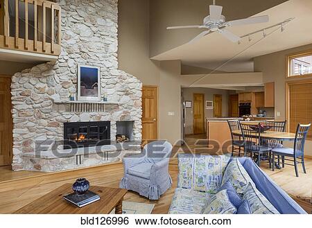 Stone fireplace between living room and dining room View Large Photo Image Stock Photograph - Stone fireplace between living room and dining room. Fotosearch