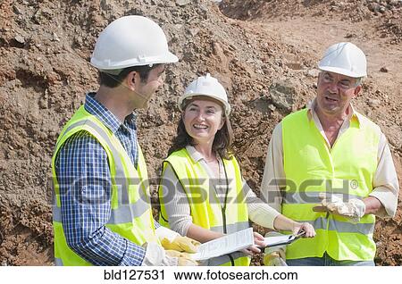 Stock Image - three engineers in construction site. Fotosearch
