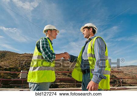 Two construction engineers shaking hands View Large Photo Image Picture - Two construction engineers shaking hands. Fotosearch