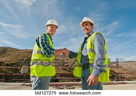 Two construction engineers shaking hands View Large Photo Image Stock Photography - Two construction engineers shaking hands. Fotosearch