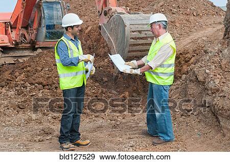 two engineers with plans in construction site View Large Photo Image Stock Photo - two engineers with plans in construction site. Fotosearch