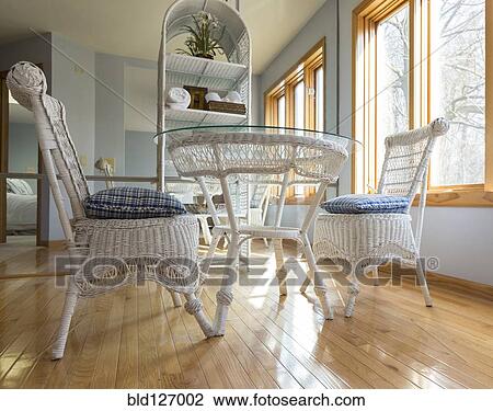 Stock Image - Wicker chairs and table in dining room. Fotosearch
