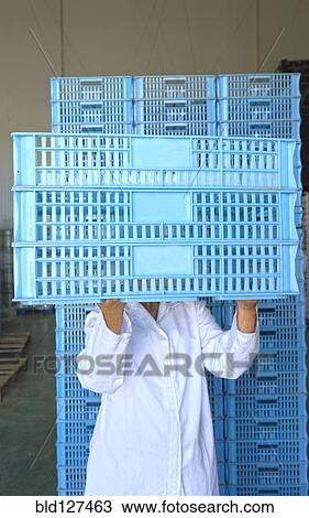 Woman holding crates in front of face View Large Photo Image Stock Image - Woman holding crates in front of face. Fotosearch