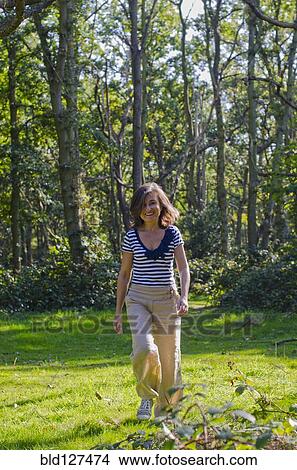 woman walking across clearing in forest View Large Photo Image Picture - woman walking across clearing in forest. Fotosearch