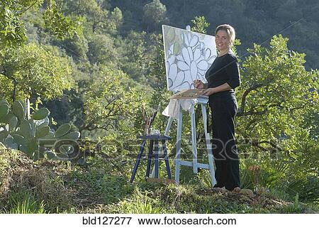 Stock Photo - Woman with canvas smiling portrait. Fotosearch
