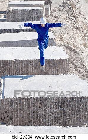 worker jumping between blocks of marble View Large Photo Image Picture - worker jumping between blocks of marble. Fotosearch